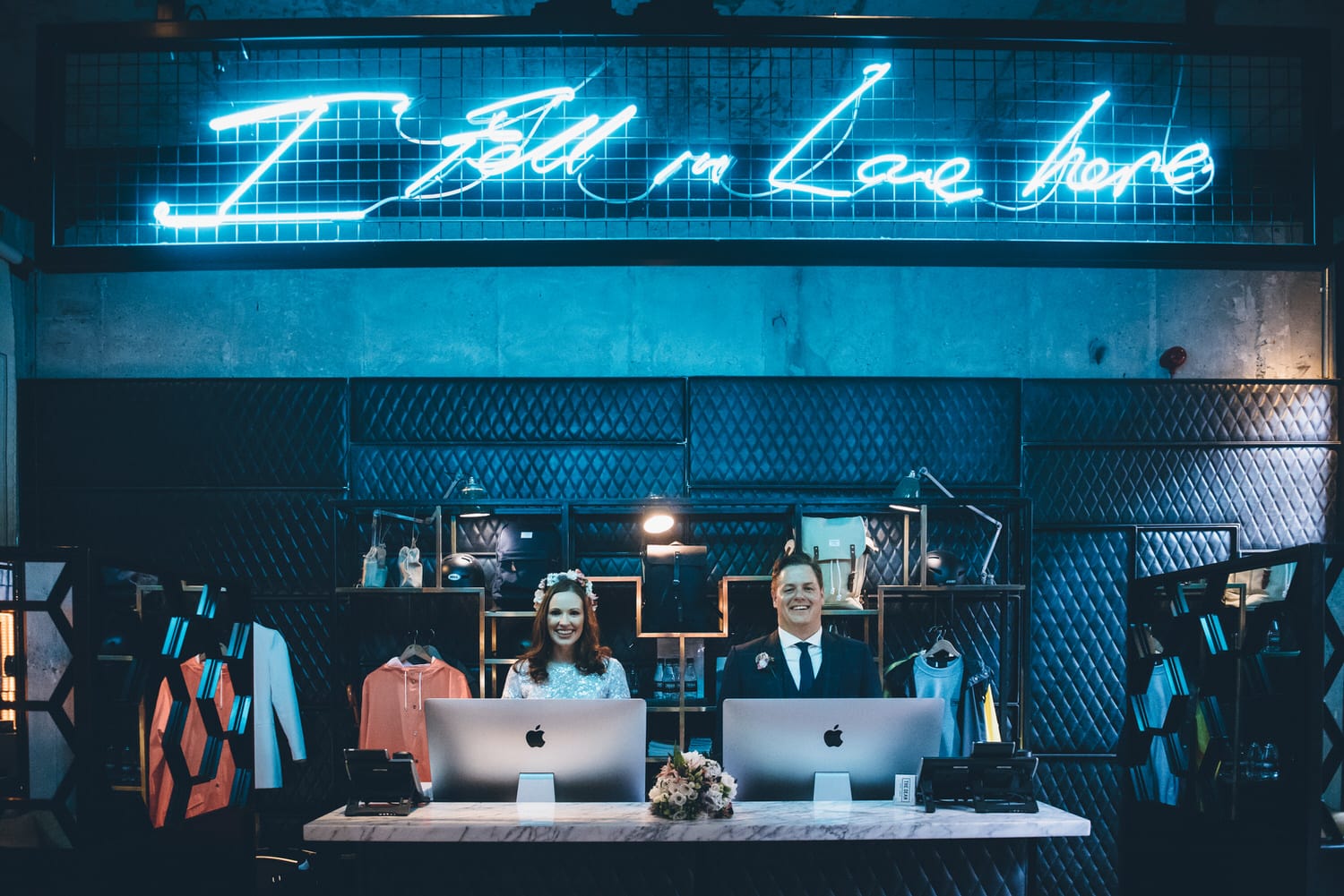 Wedding Couple standing together under a large blue neon sign that reads "I Fell In Love Here" at The Dean Hotel in Dublin, Ireland