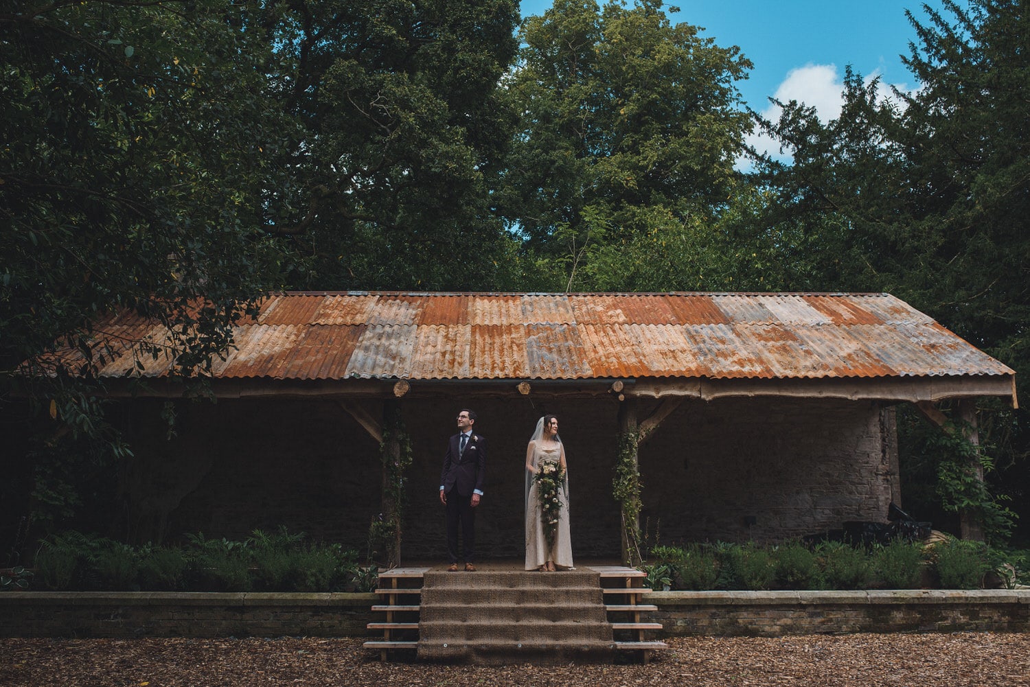 Quirky wedding image of a couple under a rusty tin roof taken at Martinstown House. 